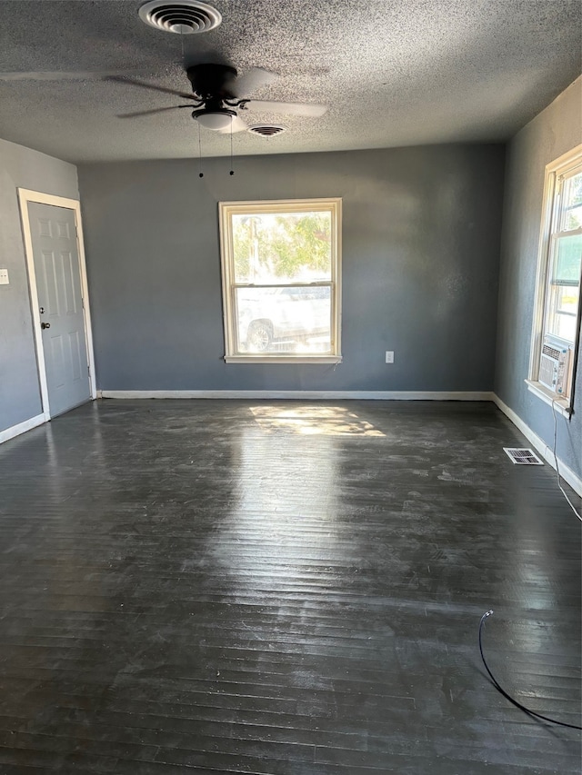 empty room featuring dark hardwood / wood-style flooring, a textured ceiling, and ceiling fan