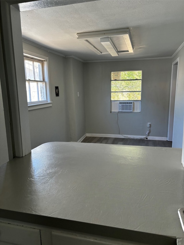 empty room featuring ornamental molding, hardwood / wood-style floors, plenty of natural light, and cooling unit