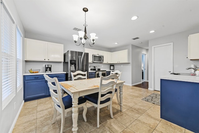 dining area with light tile patterned floors, sink, and an inviting chandelier