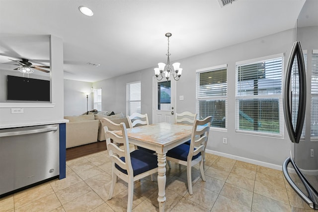 tiled dining area with a healthy amount of sunlight and ceiling fan with notable chandelier