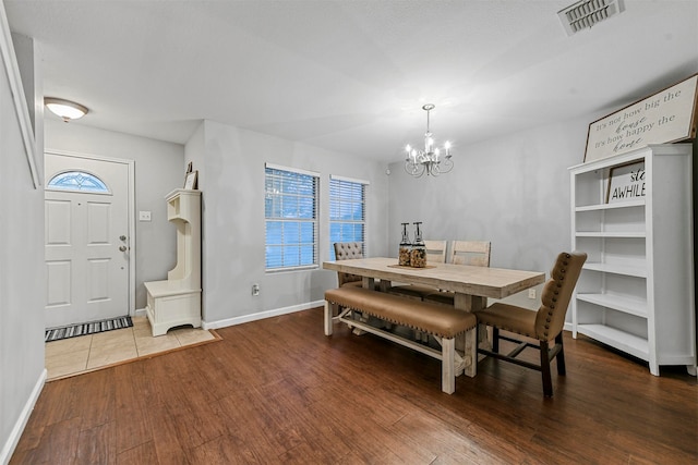 dining area with hardwood / wood-style floors and a chandelier