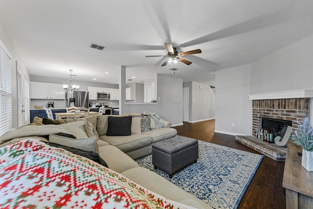 living room with a fireplace, ceiling fan with notable chandelier, and dark hardwood / wood-style flooring