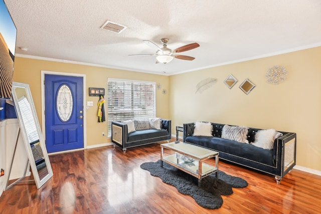 living room featuring dark hardwood / wood-style flooring, ceiling fan, a textured ceiling, and ornamental molding