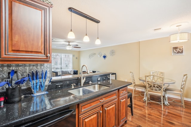 kitchen with dishwasher, hardwood / wood-style flooring, sink, ceiling fan, and backsplash