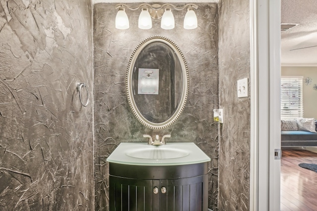 bathroom with hardwood / wood-style floors, vanity, and a textured ceiling