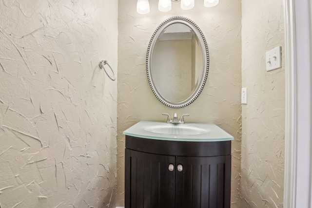 bathroom featuring a textured wall and vanity