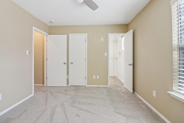 unfurnished bedroom featuring carpet floors, multiple windows, and baseboards