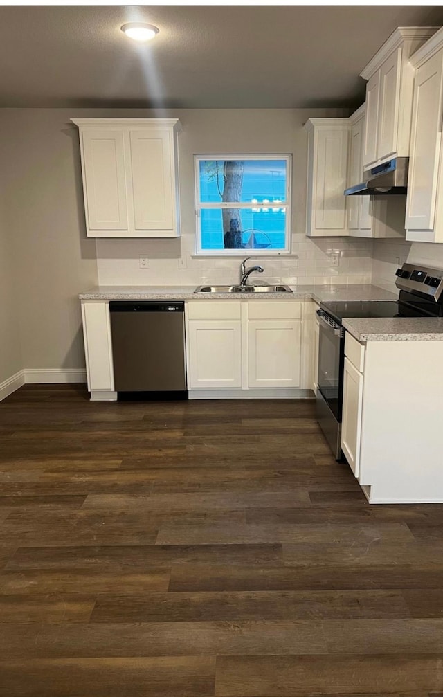 kitchen with dark wood-type flooring, sink, tasteful backsplash, white cabinetry, and stainless steel appliances