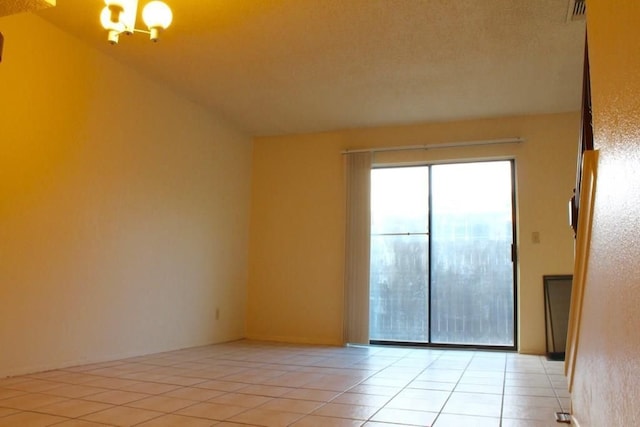 unfurnished room with a chandelier, a textured ceiling, light tile patterned floors, and lofted ceiling