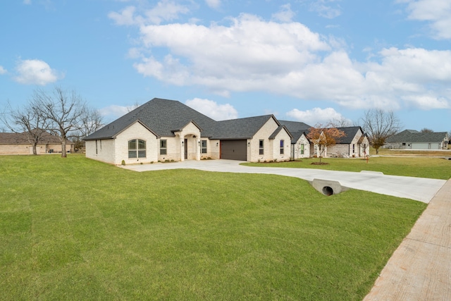 french provincial home with a garage and a front lawn