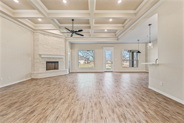 unfurnished living room with hardwood / wood-style floors, coffered ceiling, ceiling fan, ornamental molding, and a fireplace