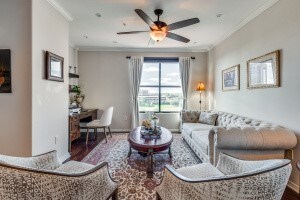 living room featuring hardwood / wood-style floors, ceiling fan, and crown molding