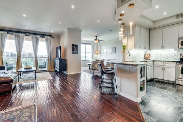 kitchen with stone countertops, white cabinetry, sink, dark hardwood / wood-style floors, and crown molding