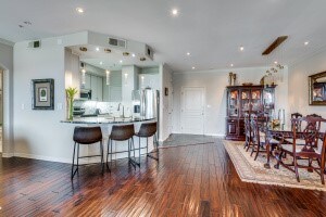 kitchen with ornamental molding, kitchen peninsula, dark wood-type flooring, and stainless steel refrigerator