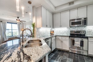 kitchen featuring sink, appliances with stainless steel finishes, light stone countertops, ceiling fan, and white cabinets