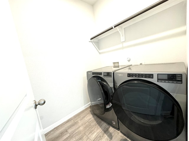 clothes washing area with light wood-type flooring and washer and dryer