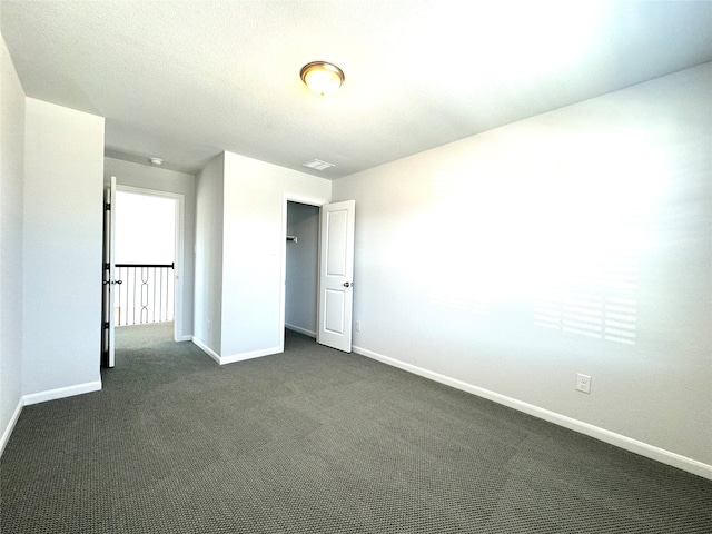 unfurnished bedroom featuring dark carpet