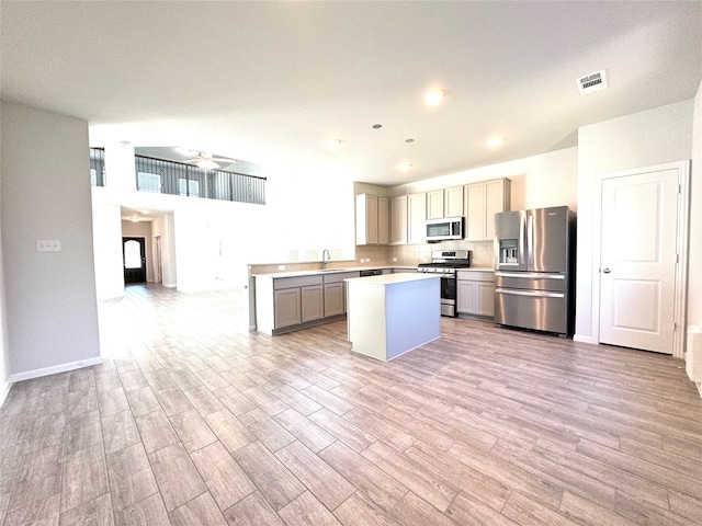 kitchen featuring appliances with stainless steel finishes, light hardwood / wood-style floors, and a center island