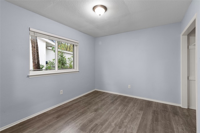 unfurnished bedroom featuring dark wood-type flooring and a textured ceiling