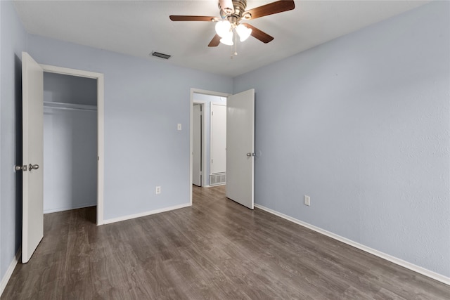 unfurnished bedroom with ceiling fan, dark hardwood / wood-style floors, and a closet