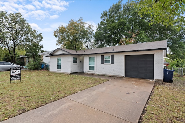 ranch-style house with a garage and a front lawn