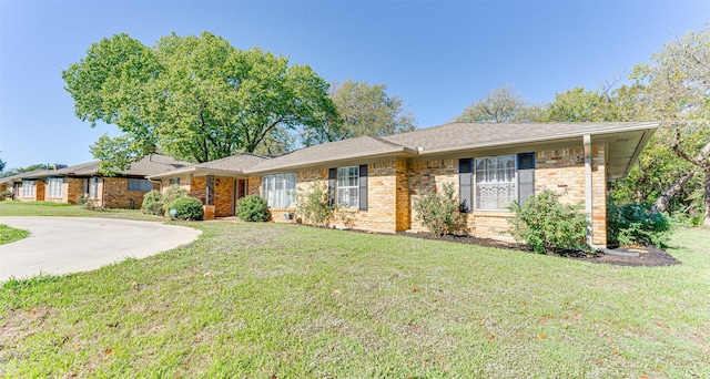 single story home featuring driveway, a front yard, and brick siding