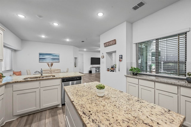 kitchen featuring dark wood-type flooring, light stone counters, white cabinetry, sink, and dishwasher