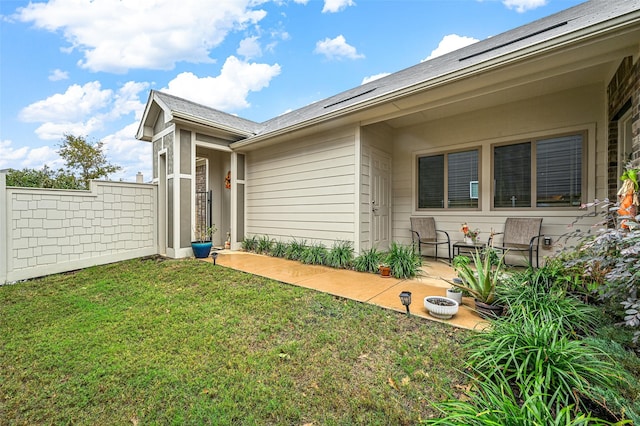 back of house featuring a lawn and a patio