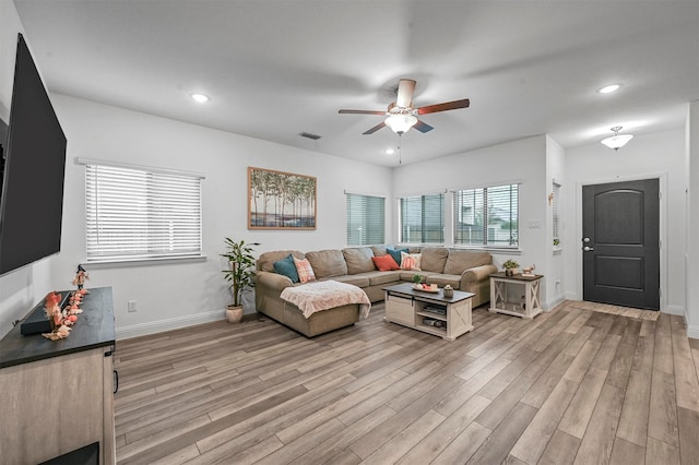 living room with light hardwood / wood-style floors and ceiling fan