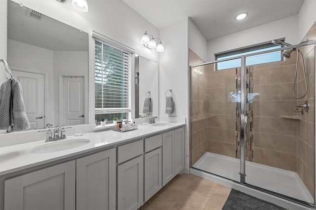 bathroom with a shower with shower door, vanity, tile patterned floors, and plenty of natural light