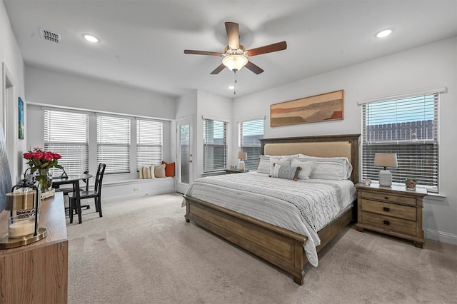 bedroom with ceiling fan, multiple windows, and light colored carpet