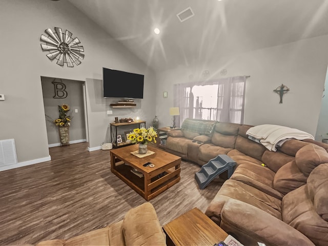 living room with dark wood-type flooring and high vaulted ceiling