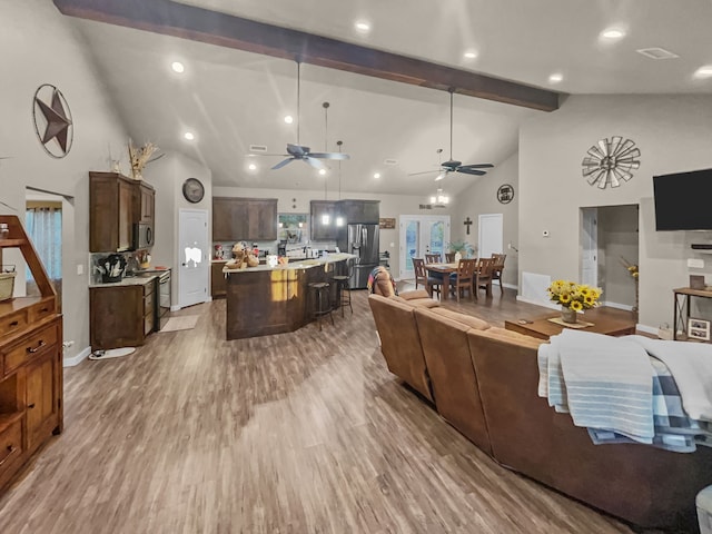 living room with high vaulted ceiling, hardwood / wood-style floors, beamed ceiling, and ceiling fan