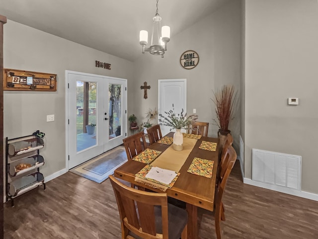 dining room featuring french doors, a notable chandelier, dark wood-type flooring, and vaulted ceiling