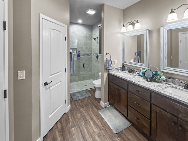 bathroom featuring hardwood / wood-style flooring, vanity, toilet, and walk in shower