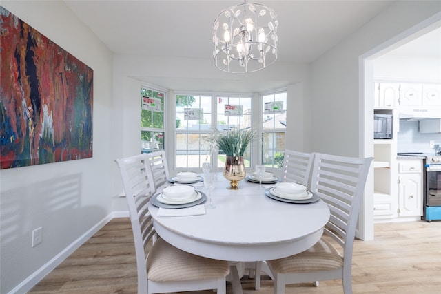 dining room featuring light wood-type flooring and an inviting chandelier