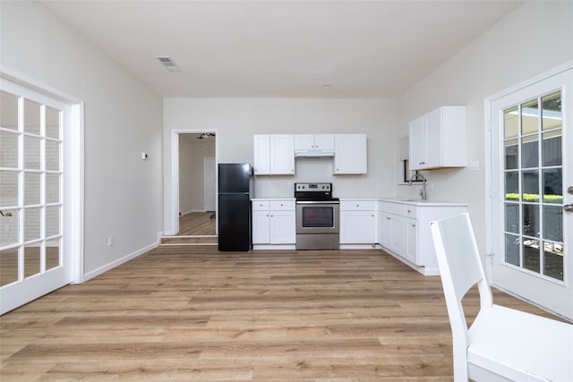 kitchen featuring black fridge, sink, stainless steel electric stove, white cabinetry, and light hardwood / wood-style flooring