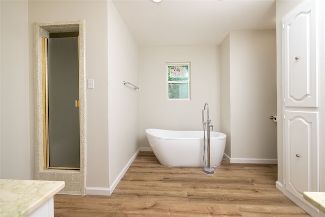 bathroom with shower with separate bathtub, wood-type flooring, and vanity