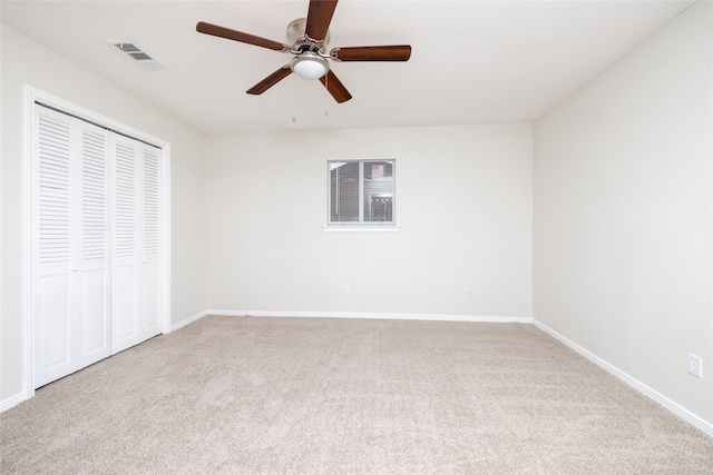 unfurnished bedroom with light carpet, ceiling fan, and a closet