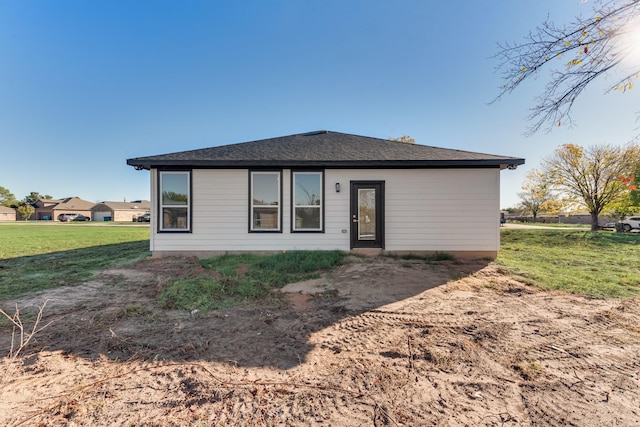 view of front of home with a shingled roof and a front lawn