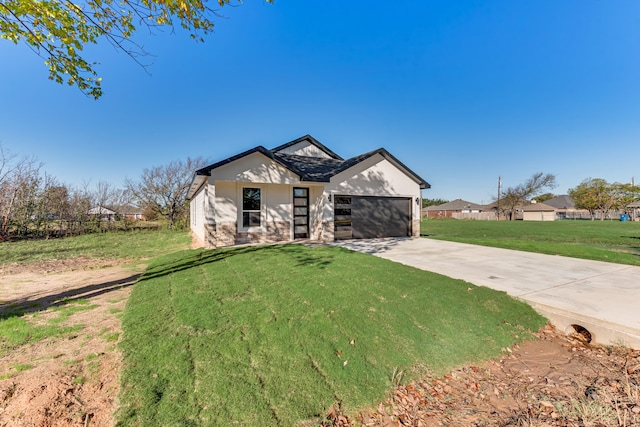 view of front of home with a garage and a front lawn