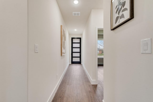 hallway featuring visible vents, baseboards, wood finished floors, and recessed lighting