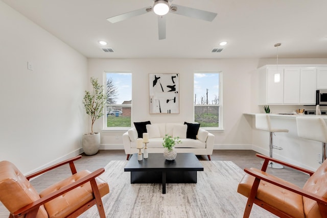 living area with light wood finished floors, plenty of natural light, and visible vents