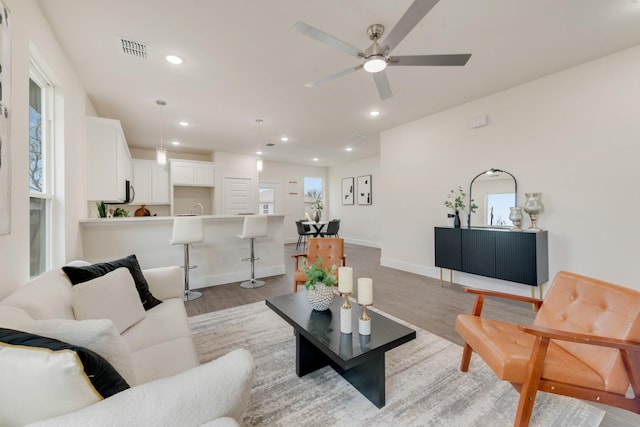 living area with a healthy amount of sunlight, light wood-style floors, visible vents, and recessed lighting