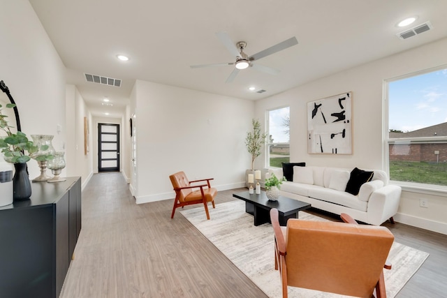 living room with light wood finished floors, baseboards, visible vents, and recessed lighting