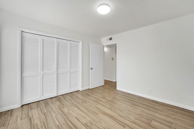 unfurnished bedroom featuring a closet and light hardwood / wood-style flooring