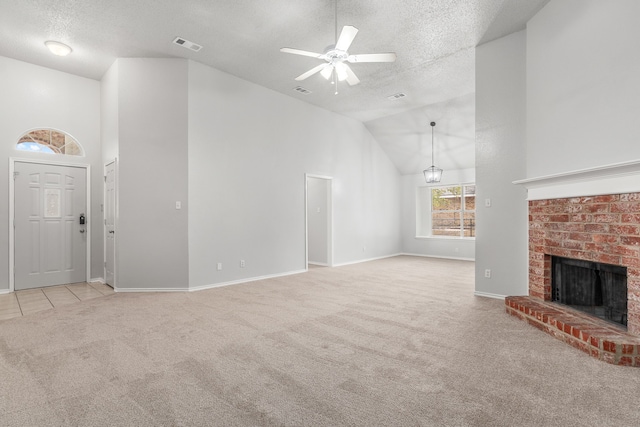 unfurnished living room featuring a textured ceiling, light carpet, ceiling fan, and a fireplace