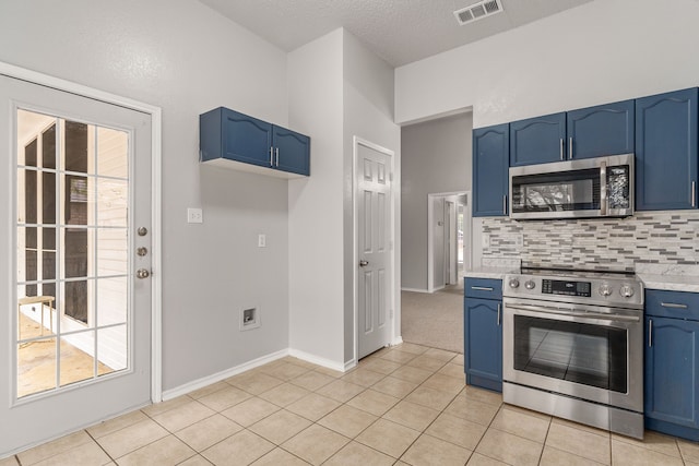 kitchen with plenty of natural light, stainless steel appliances, and blue cabinets