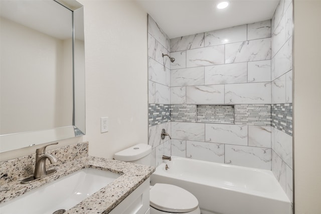 full bathroom featuring tiled shower / bath combo, vanity, and toilet