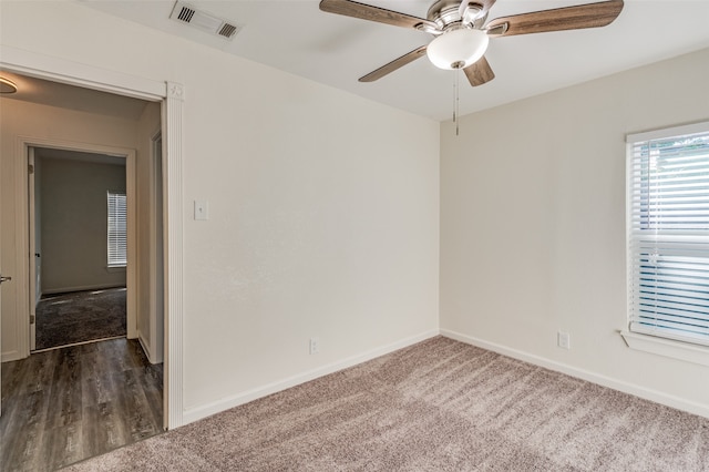 empty room with ceiling fan and dark carpet